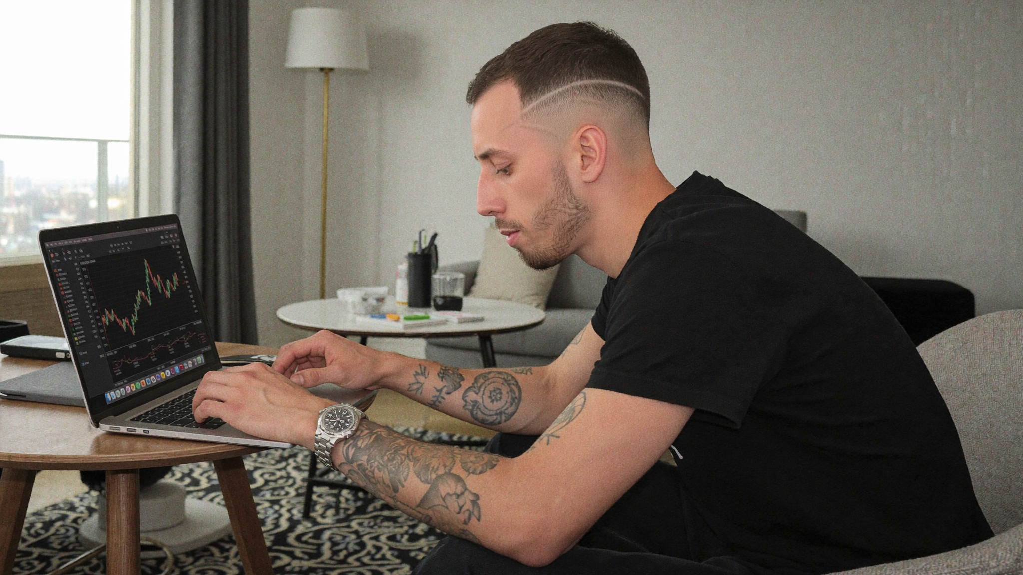 Cody Wise working on a laptop showing market charts