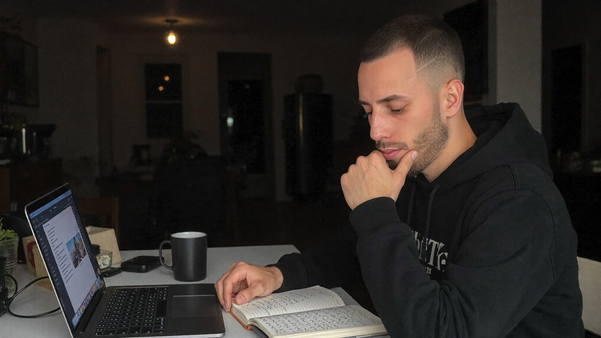 Cody Wise at a kitchen table late at night with a laptop and notebook
