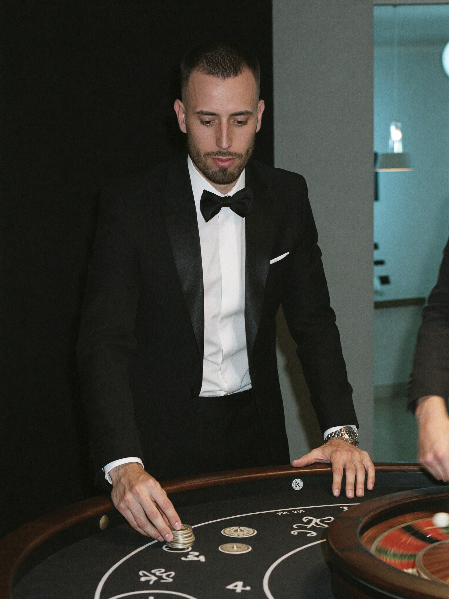 Cody Wise at a gaming table at night, placing plaques on the felt