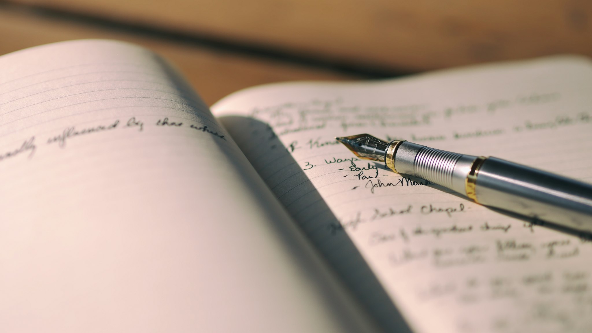 A pen resting on a sheet of lined paper on a desk