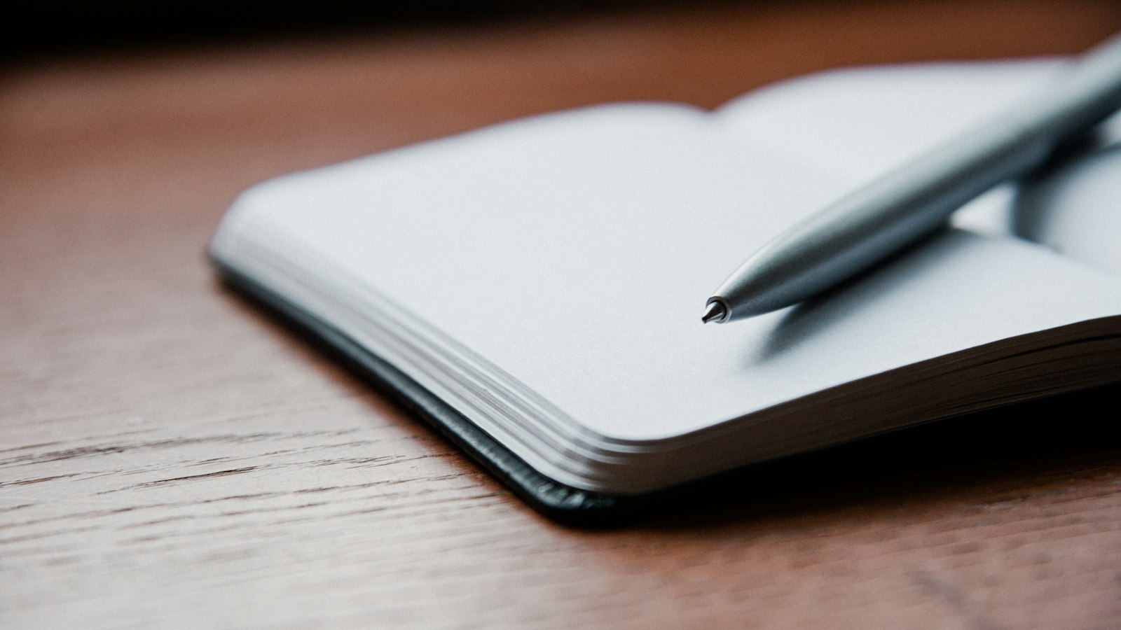 Pen resting on an open notebook, illustrating the one-line failure report every scheduled agent should send
