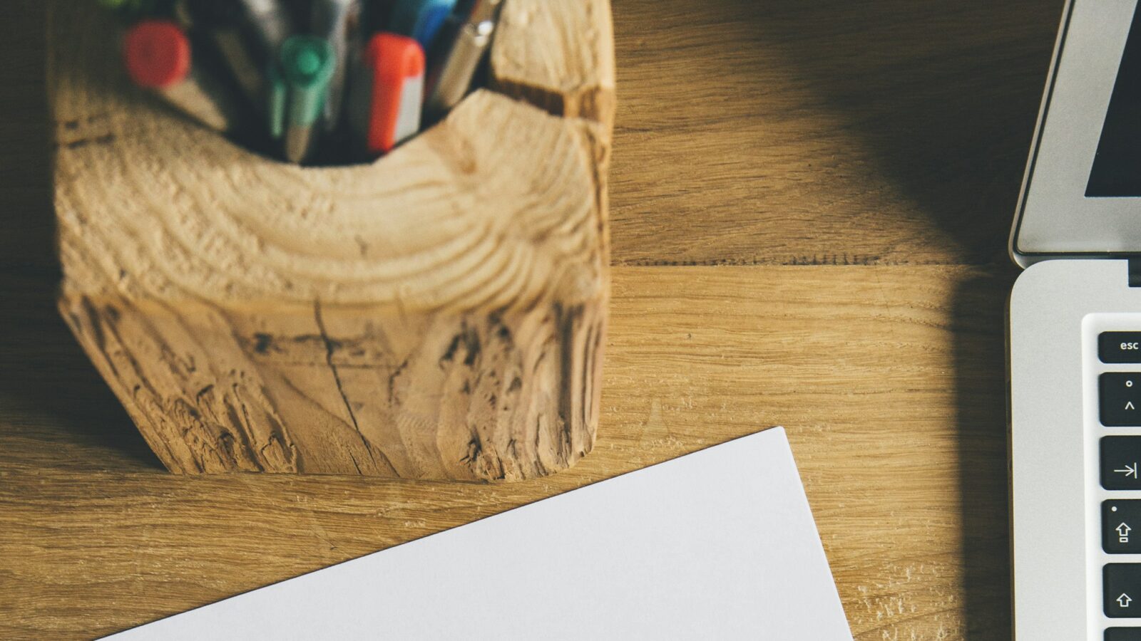 A single sheet of white paper beside a black pen on a plain desk