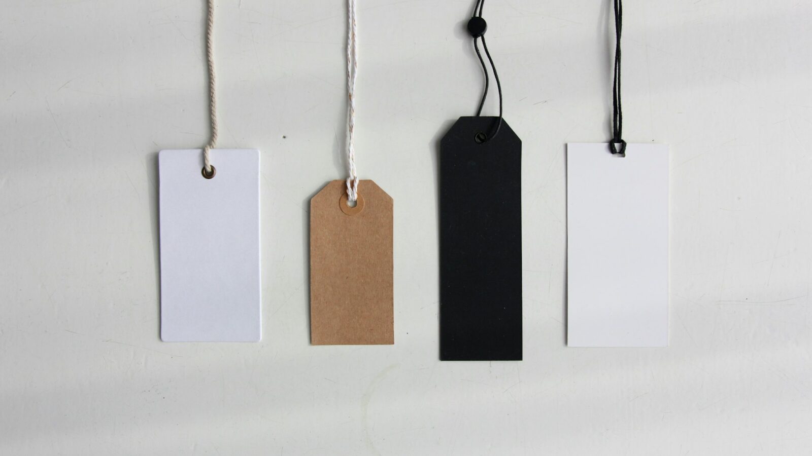 A paper price tag tied to goods on a shop counter in daylight