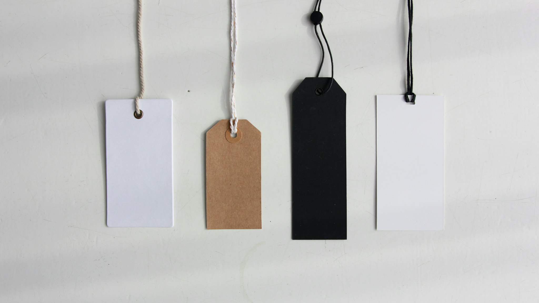 A paper price tag tied to goods on a shop counter in daylight