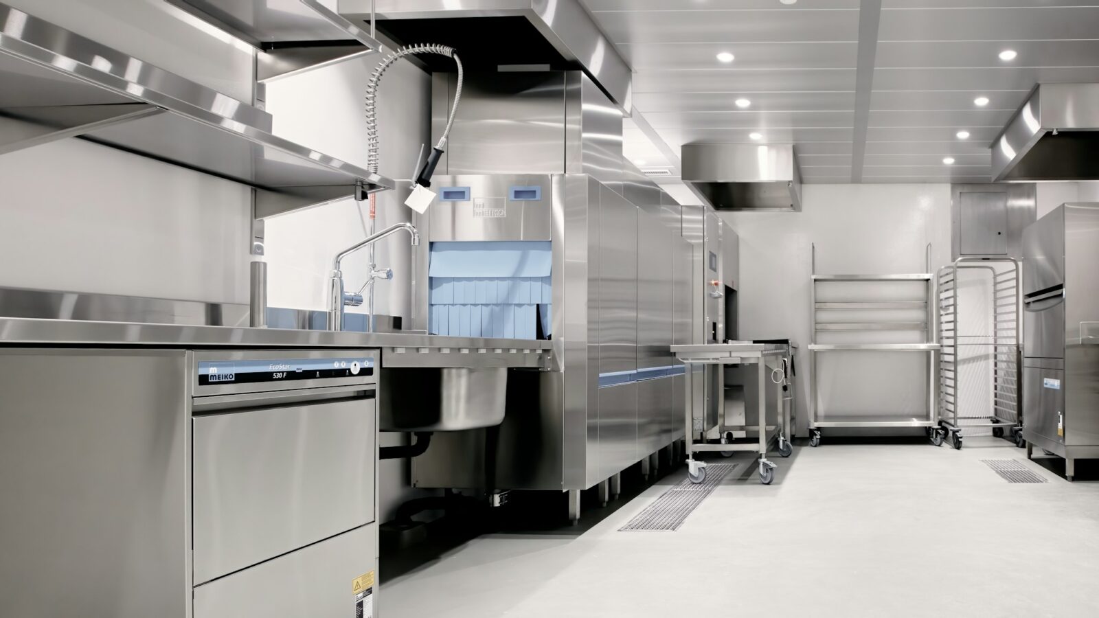 Commercial kitchen fitted out with stainless steel equipment and fixed stations
