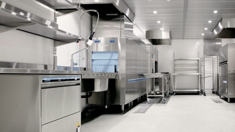 Commercial kitchen fitted out with stainless steel equipment and fixed stations