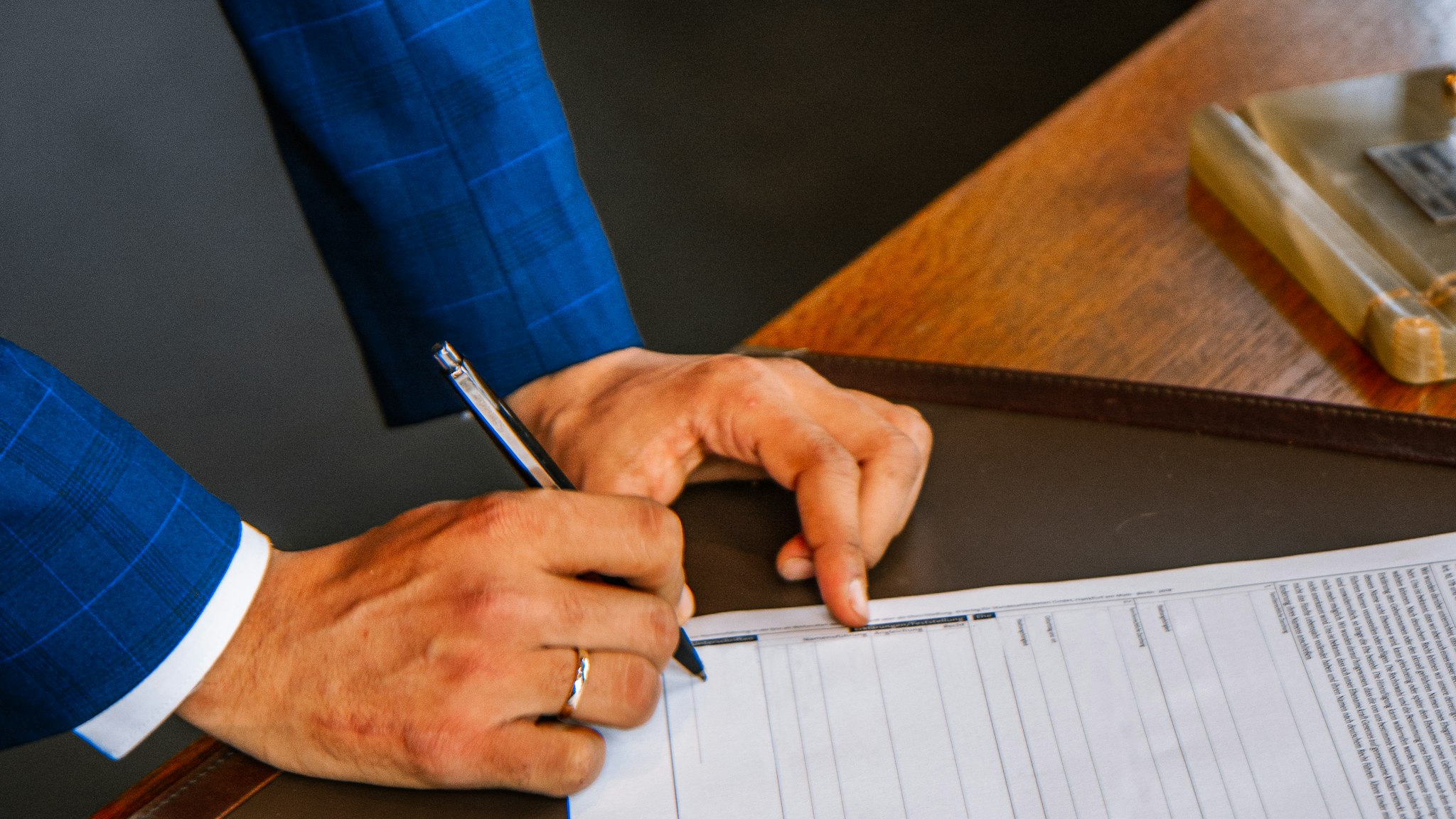 A hand writing on a single printed page with a pen