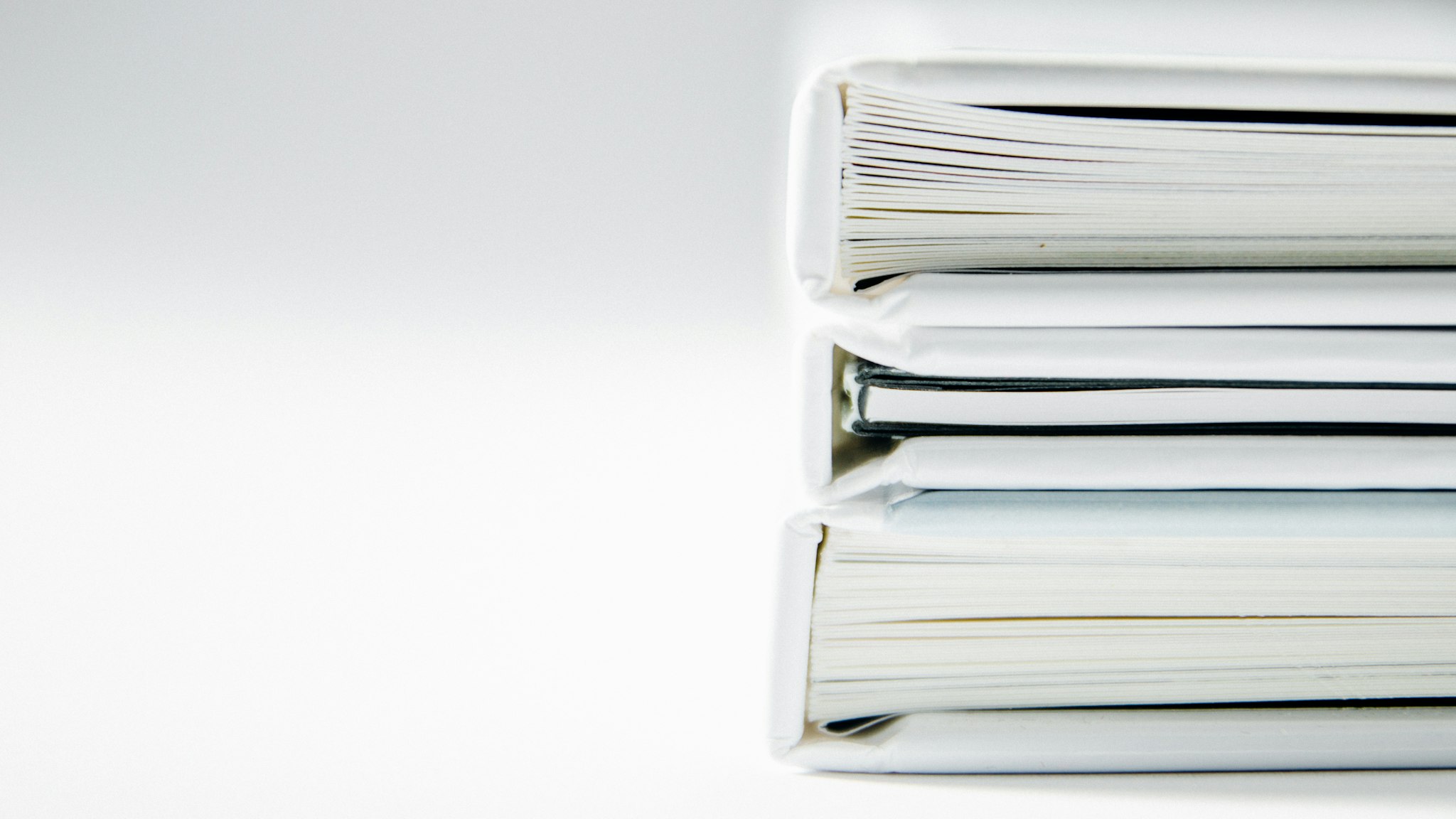 A stack of thick document folders on a white surface