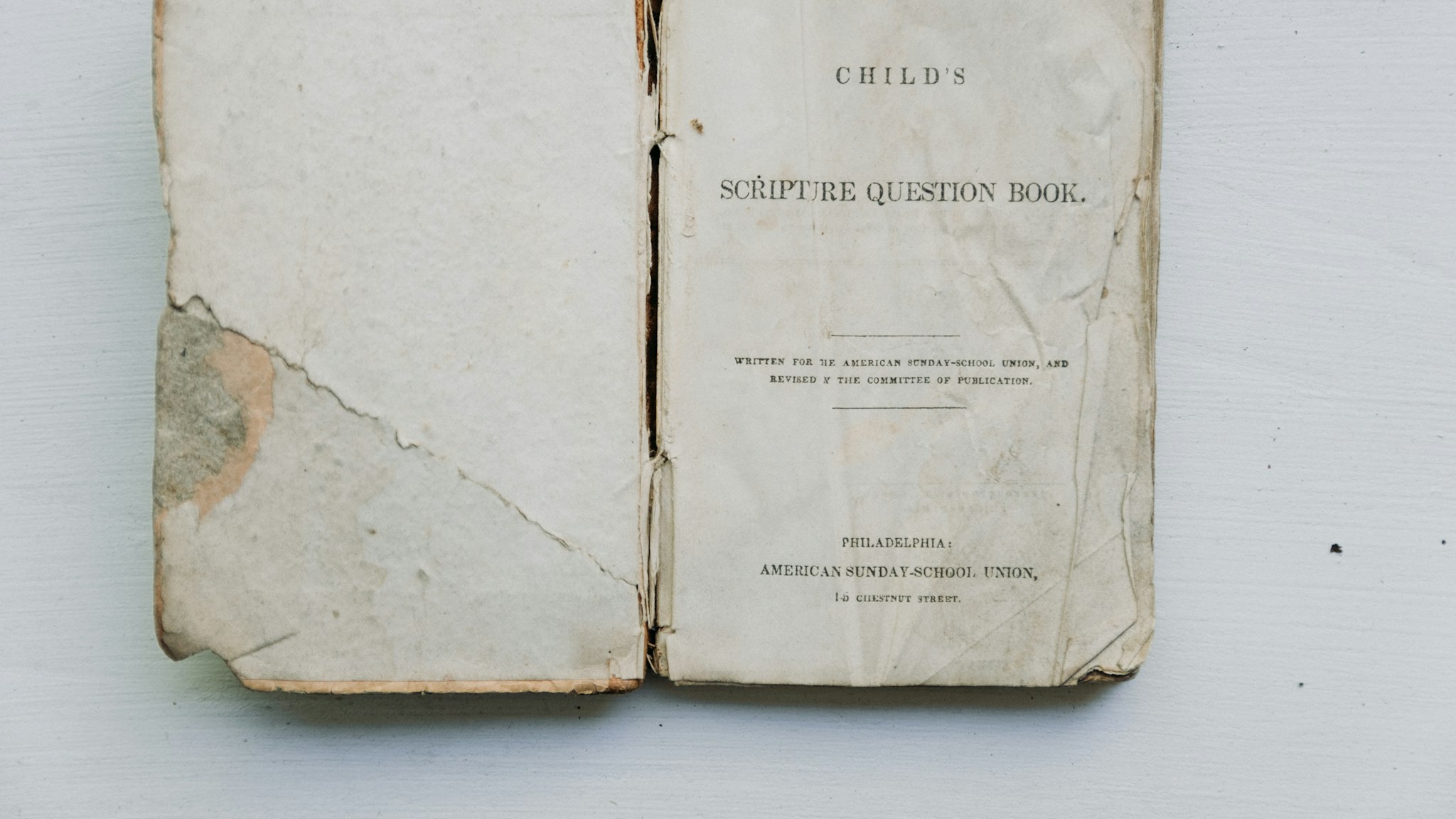 An old reference book lying open on a white surface