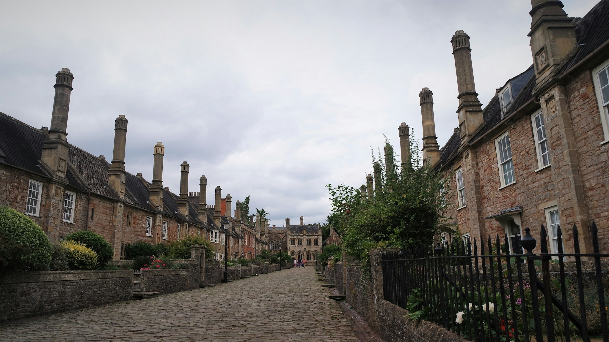 A row of old brick houses along a cobbled lane, the kind of almshouse row a foundation deed kept standing for centuries