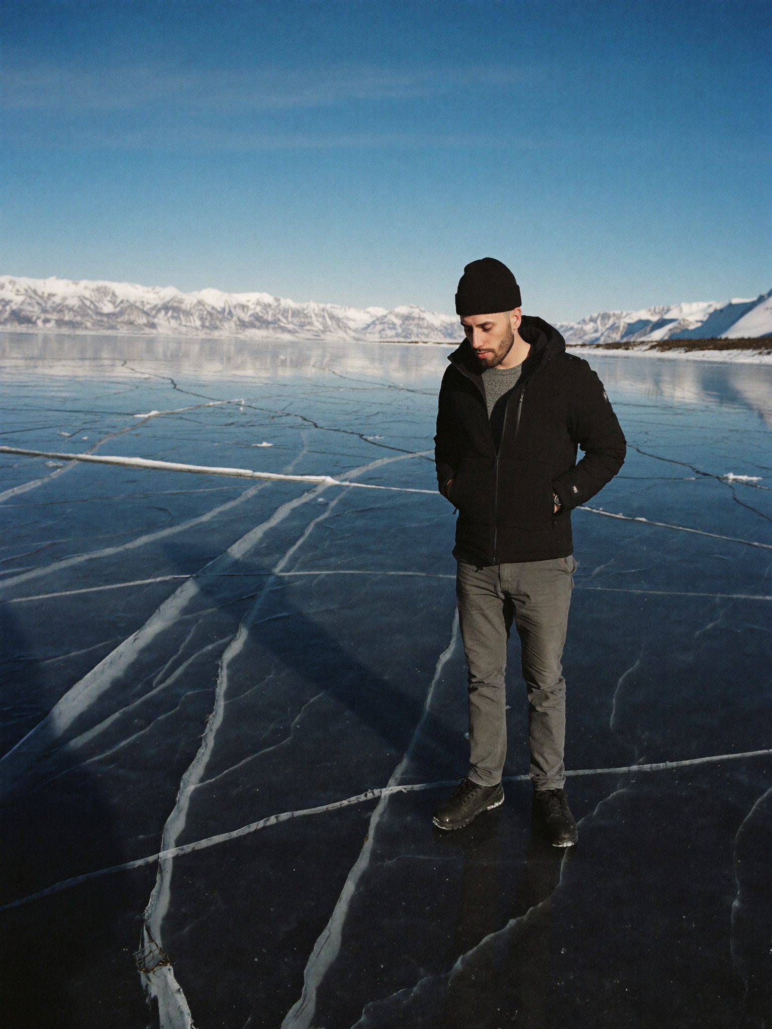 Cody Wise standing on black lake ice in the Rockies, reading the surface before trusting it