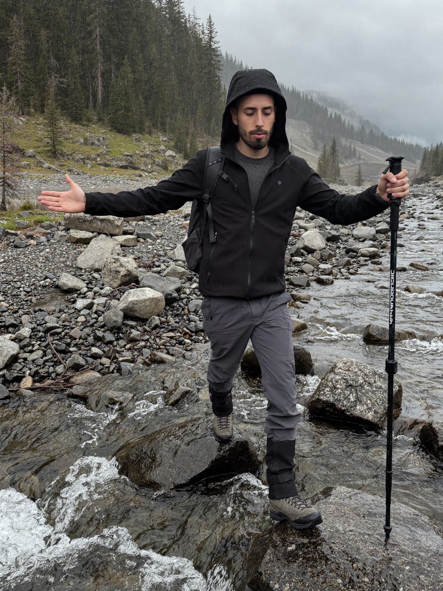 Cody Wise crossing a rain-swollen Kananaskis creek on the rocks, using the obstacle as the footing
