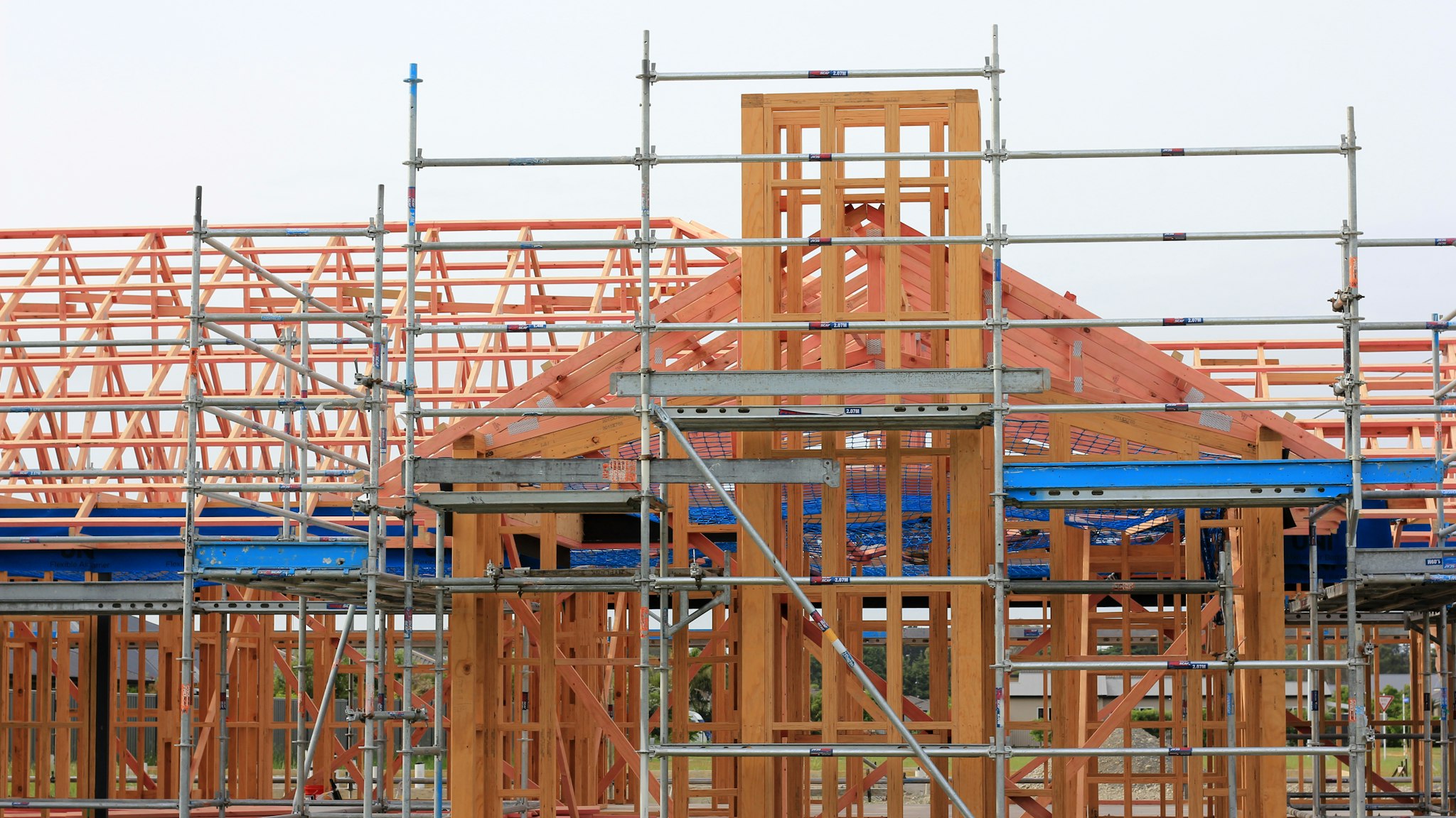 Wood framing of a new house under construction against an open sky.