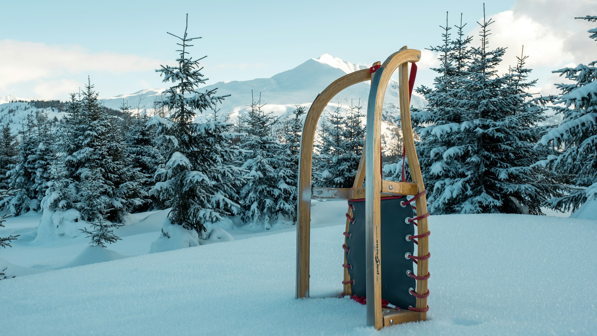 A wooden sled standing in snow, the light kit of a small party that hunts instead of hauling its supplies